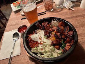 A sizzling Korean rice bowl with egg and vegetables at Cho Sun