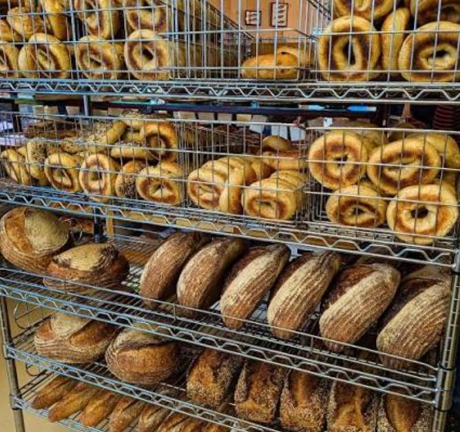 Racks filled with Gemini Bakery bagels and loaves