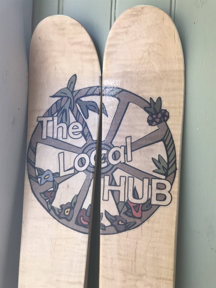 Wooden skis carrying The Local Hub artwork
