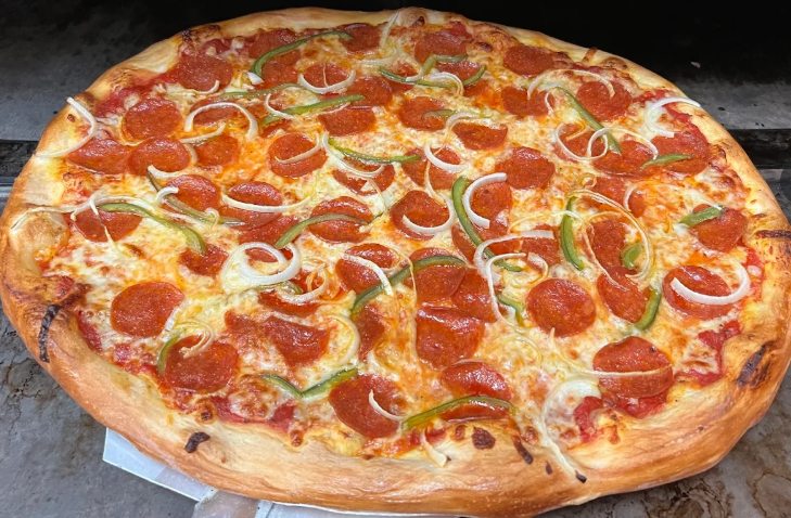 A pepperoni, onion, and green pepper pizza from Pie Hole 207